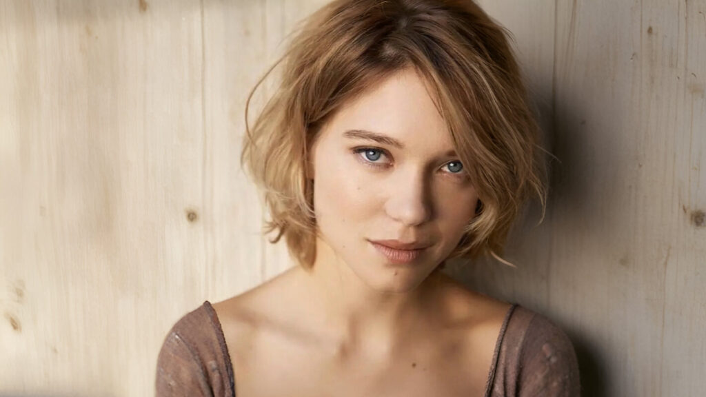Portrait of a woman with blonde bob haircut and blue eyes.